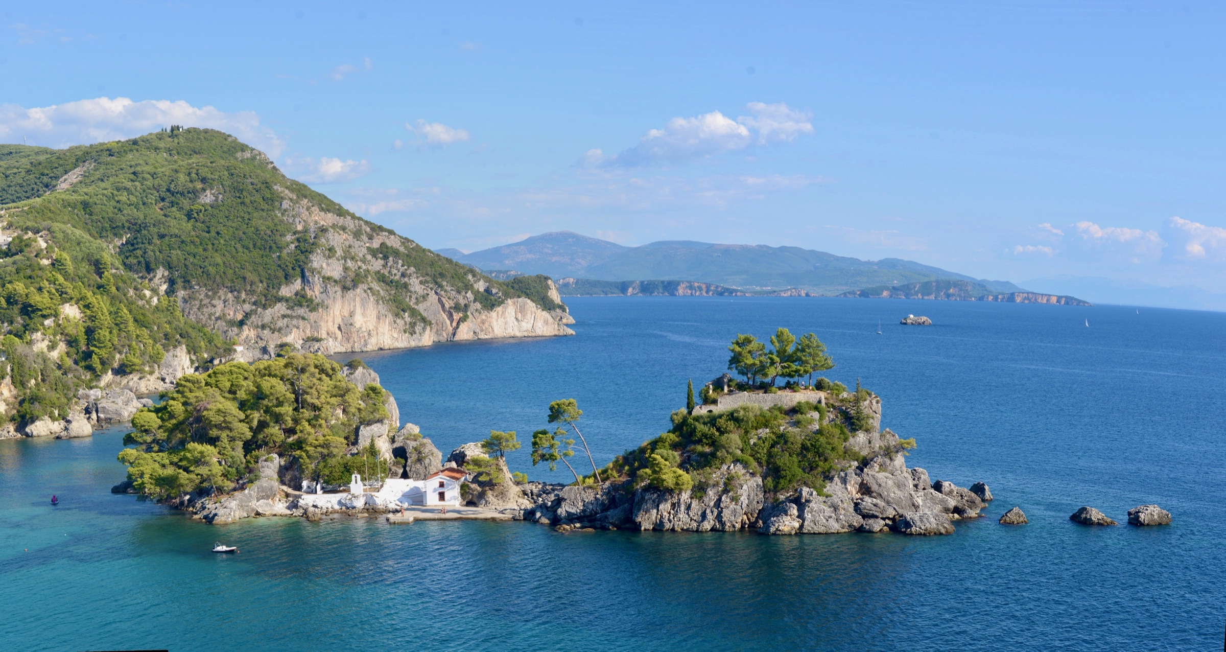 The wooded islet of Panagia with a white chapel in the turquoise sea off Parga